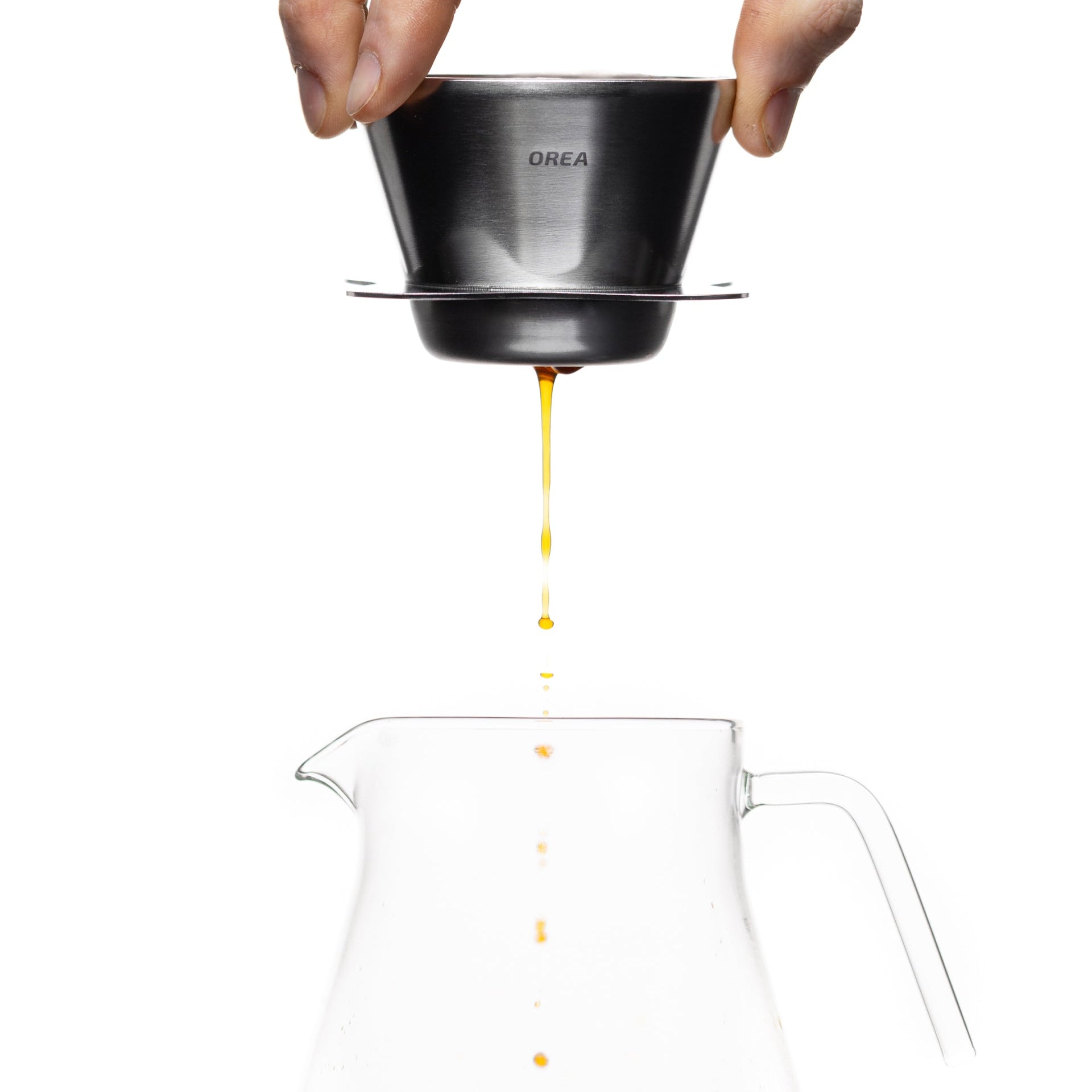 Hand pouring coffee from an Orea dripper by Komuna Coffee